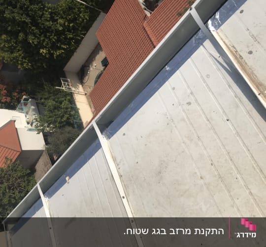 גג מתכת עם קורות לבנות ותפרים גלויים